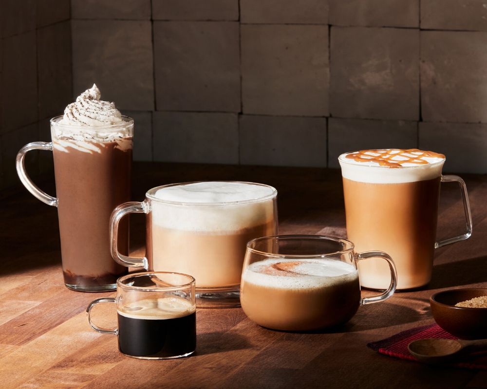 Selection of coffee drinks including espresso, latte and hot chocolate in glass cups